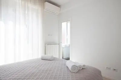 a white bedroom with a bed with towels on it at Elegant Flat in Ponte Milvio in Rome
