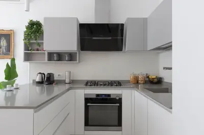 a kitchen with white cabinets and a stove top oven at Elegant Flat in Ponte Milvio in Rome
