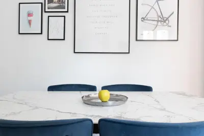 a table with two blue chairs and a yellow apple on a plate at Elegant Flat in Ponte Milvio in Rome