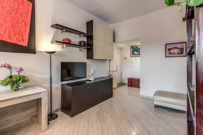 a living room with a kitchen with a couch and a television at Dante Secret Home in Rome