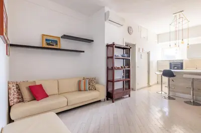 a living room with a couch and a kitchen at Dante Secret Home in Rome