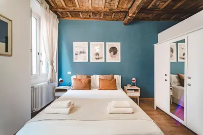 a bedroom with a large bed with a blue wall at Fancy Colosseum - Best location in Rome