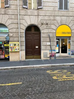 a building with a brown door on a street at Walking in the center of Rome in Rome