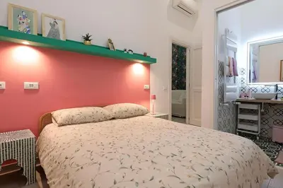 a bedroom with a large bed with a red wall at Walking in the center of Rome in Rome