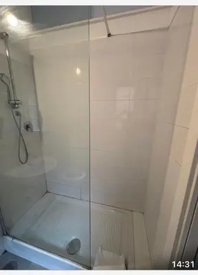 a man taking a picture of a bathroom with a shower at Sabo rooms in Rome