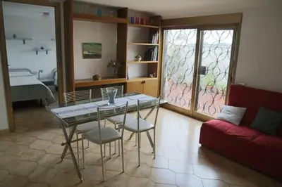 a living room with a table and chairs and a couch at Super attico Eur in Rome