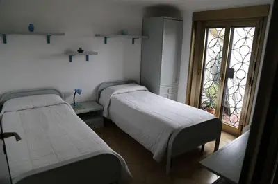two beds in a room with a window at Super attico Eur in Rome