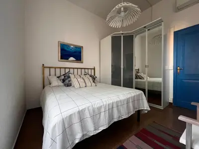 a bedroom with a bed and a blue door at Domus Ele in Rome