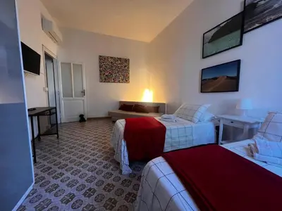 a hotel room with two beds and a couch at Domus Ele in Rome