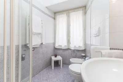 a white bathroom with a toilet and a sink at La Casetta Furio Camillo in Rome