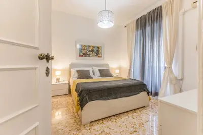 a white bedroom with a bed and a window at La Casetta Furio Camillo in Rome