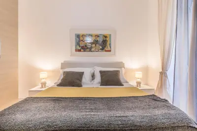 a bedroom with a large bed with two lamps at La Casetta Furio Camillo in Rome