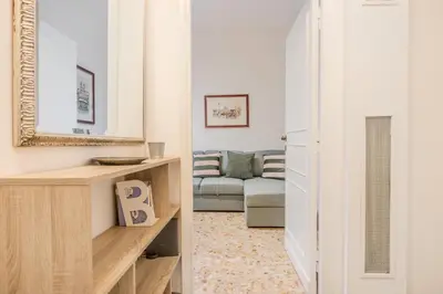 a living room with a couch and a mirror at La Casetta Furio Camillo in Rome