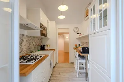 a kitchen with white cabinets and a stove top oven at Toto Vatican Suite in Rome