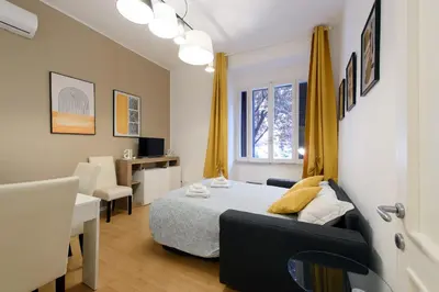 a bedroom with a bed and a desk and a chair at Toto Vatican Suite in Rome