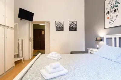 a bedroom with a blue bed with towels on it at Toto Vatican Suite in Rome