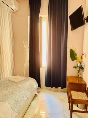 a bedroom with a bed and a window at Ines Guest House in Rome