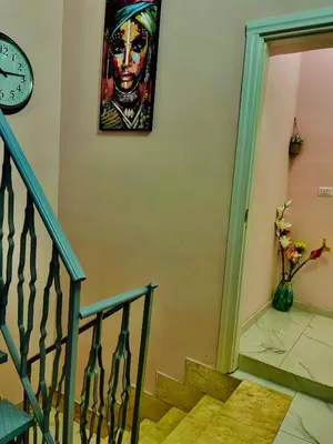 a painting of a woman on a wall next to a staircase at Ines Guest House in Rome