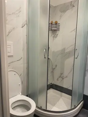 a bathroom with a toilet and a glass shower at Ines Guest House in Rome