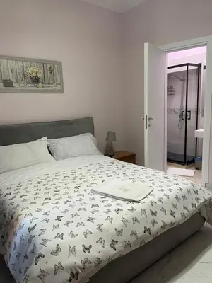 a bedroom with a bed with a comforter on it at Ines Guest House in Rome
