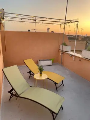 a patio with two chairs and a table on a roof at Monti View Apartment in Rome