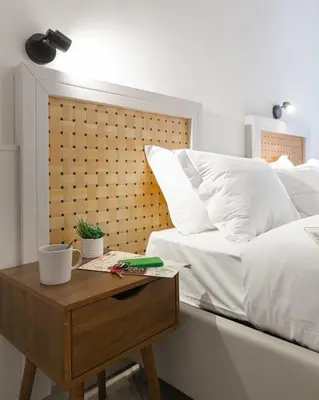 a bed with white pillows and a wooden table with a night stand at Rental in Rome Guest House 2-ZEN51 in Rome