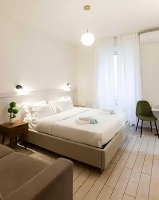a bedroom with a large white bed and a couch at Rental in Rome Guest House 2-ZEN51 in Rome