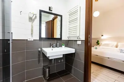 a bathroom with a sink and a mirror and a bed at Rental in Rome Guest House 2-ZEN51 in Rome