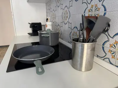 a kitchen counter with a frying pan and utensils at Piramide-Ostiense Two Bedroom Apartment in Rome