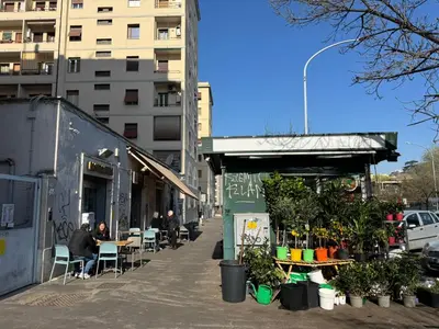 a building with tables and chairs on a city street at Piramide-Ostiense Two Bedroom Apartment in Rome