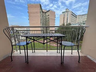 a table and chairs on a balcony with buildings at Piramide-Ostiense Two Bedroom Apartment in Rome