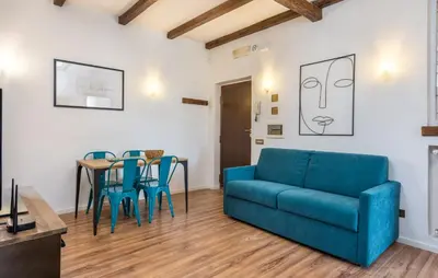 a living room with a blue couch and a table at Vaticano-Metro A 1 min, Urban Rooftop in Rome