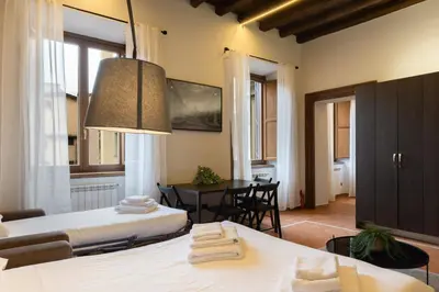 a room with two beds and a dining room at Elegant Prefetti Home in Rome