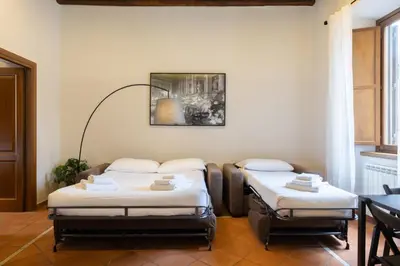 two beds in a room with a picture on the wall at Elegant Prefetti Home in Rome