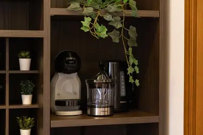 a shelf with a coffee maker and a blender on it at Elegant Prefetti Home in Rome