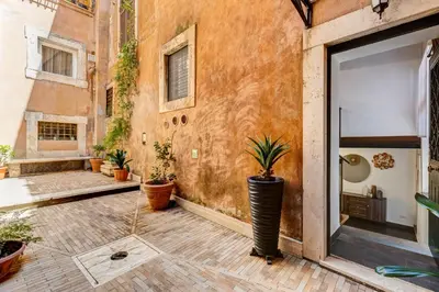 a courtyard with potted plants in a building at Trastevere Piazza Trilussa Royal Orchid apartment in Rome
