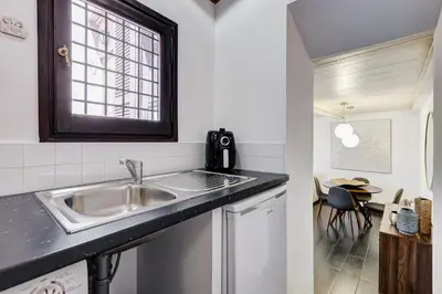 a kitchen with a sink and a table at Trastevere Piazza Trilussa Royal Orchid apartment in Rome