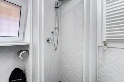 a shower in a bathroom with a shower curtain at Trastevere Piazza Trilussa Royal Orchid apartment in Rome