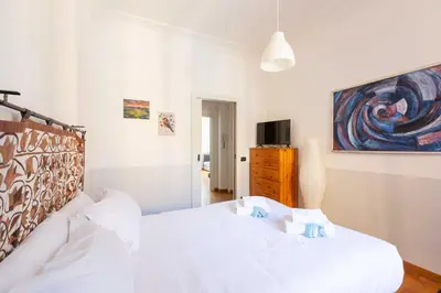 a bedroom with a white bed and a painting on the wall at Belle Arti Zen Apartment- Cale 03 in Rome