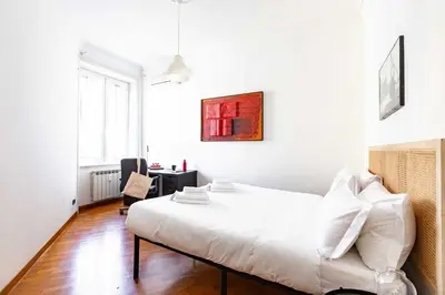 a white bedroom with a bed and a desk at Belle Arti Zen Apartment- Cale 03 in Rome