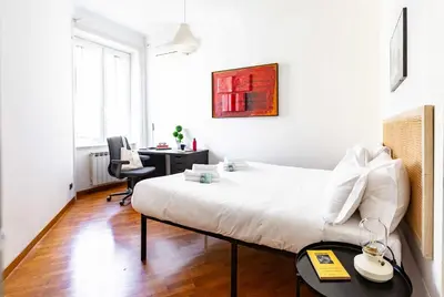 a white bedroom with a bed and a desk at Belle Arti Zen Apartment- Cale 03 in Rome