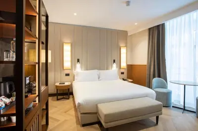 a hotel room with a white bed and a chair at Circle6 Rome in Rome