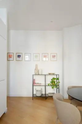 a white living room with a table and a chair at Aeterna Suites Roma in Rome