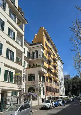 a tall building with cars parked in front of it at Aeterna Suites Roma in Rome