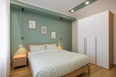 a bedroom with a bed and a green wall at Aurelius Design Loft 2 in Rome