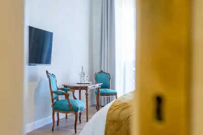 a room with two chairs and a table and a television at Elegance and Style near St Peter's in Rome