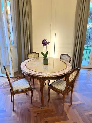 a table with chairs and a vase with flowers on it at Elegance and Style near St Peter's in Rome