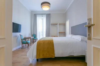 a bedroom with a white bed and a table and chairs at Elegance and Style near St Peter's in Rome