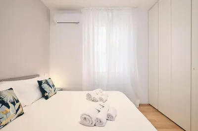 a white bedroom with towels on a bed at Elegant Apartment near the Centre - Wi-Fi & Netflix Free in Rome