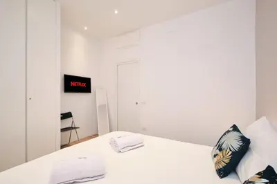 a white bedroom with a white bed with two towels at Elegant Apartment near the Centre - Wi-Fi & Netflix Free in Rome
